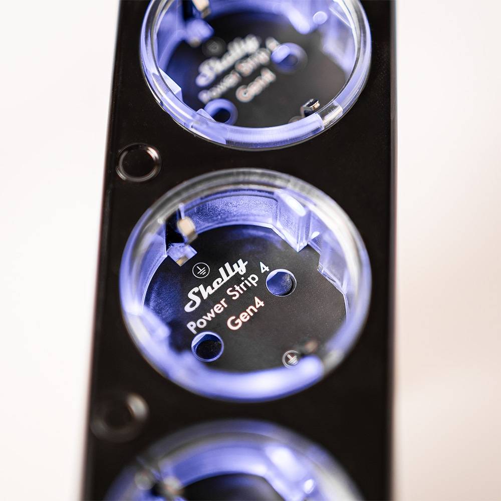 Nahaufnahme eines 'Shelly Power Strip 4 Gen4', bei der drei runde Steckdosen mit einem eleganten schwarz-blauen Design zu sehen sind.