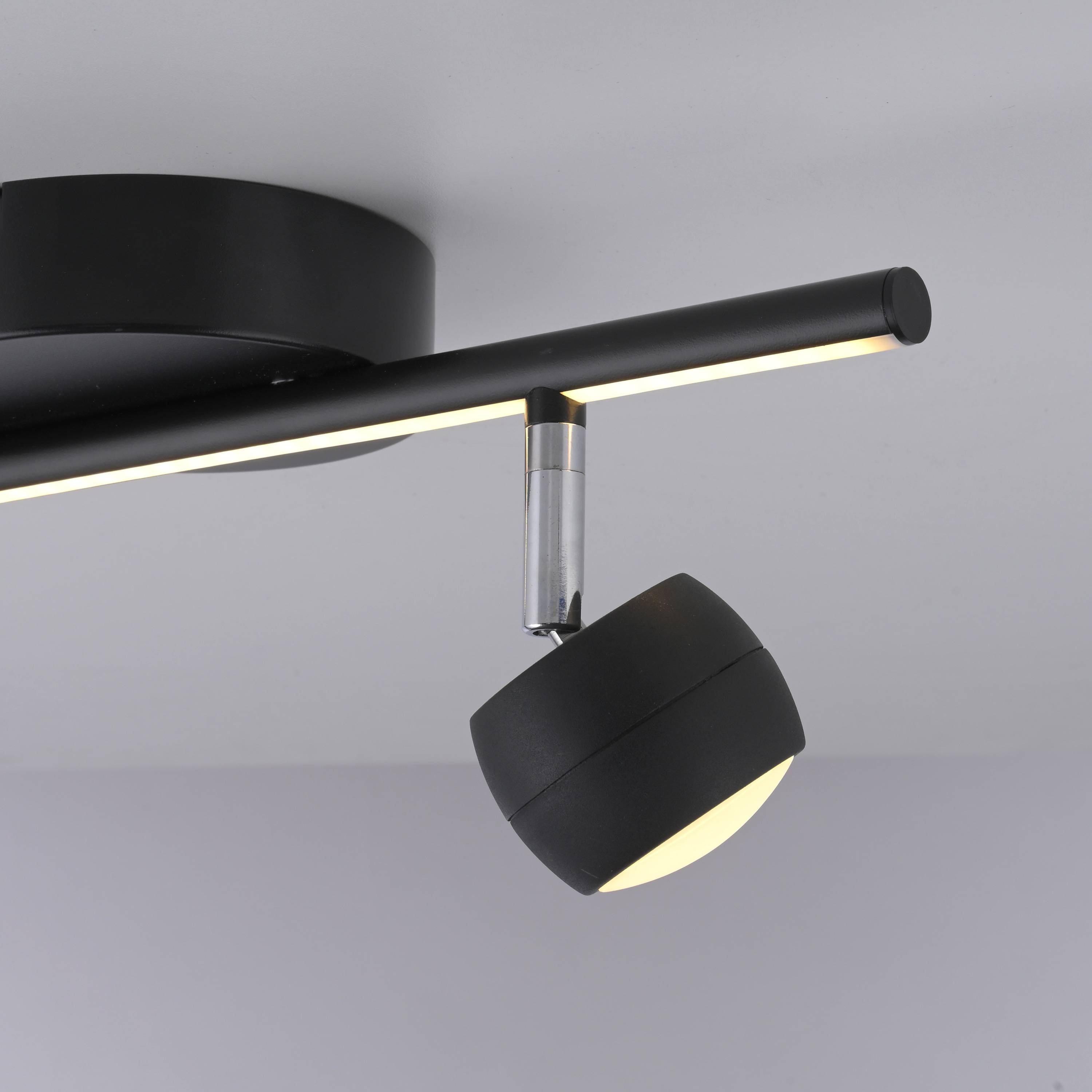 Eine moderne schwarze Deckenleuchte mit einem rotierenden zylindrischen Lampenkörper in minimalistischem Design, die ein nach unten gerichtetes Licht ausstrahlt.