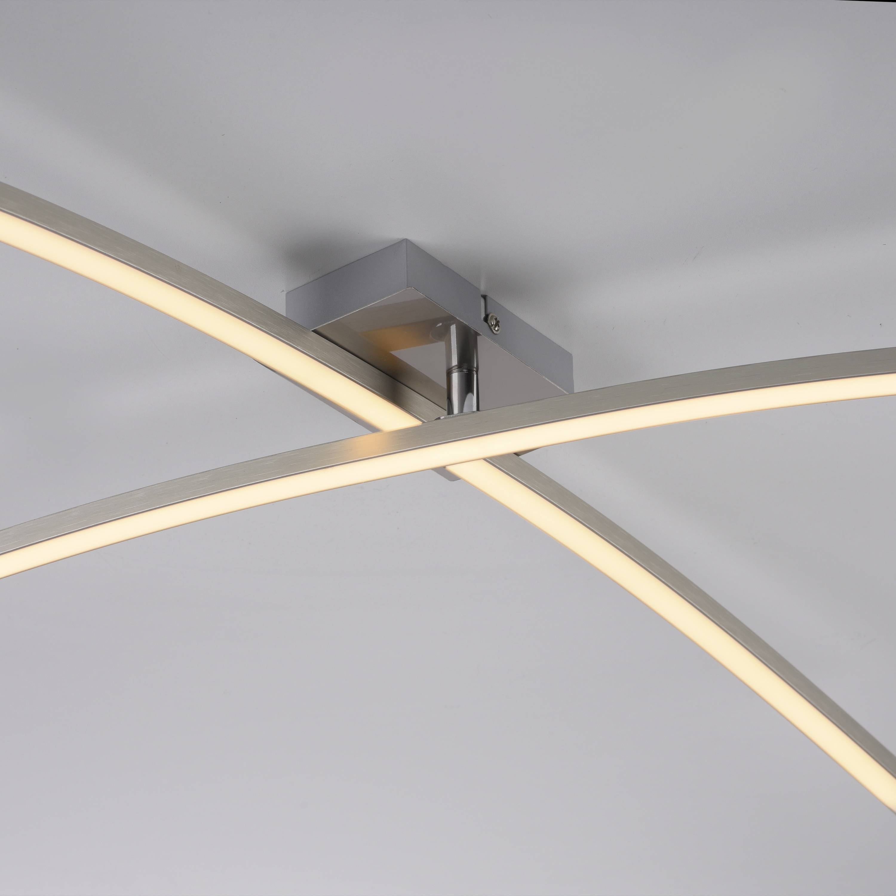 Eine moderne, geschwungene LED-Deckenleuchte mit cleanen Linien und einem minimalistischen Design, an einer grauen Decke für zeitgenössische Raumgestaltung montiert.