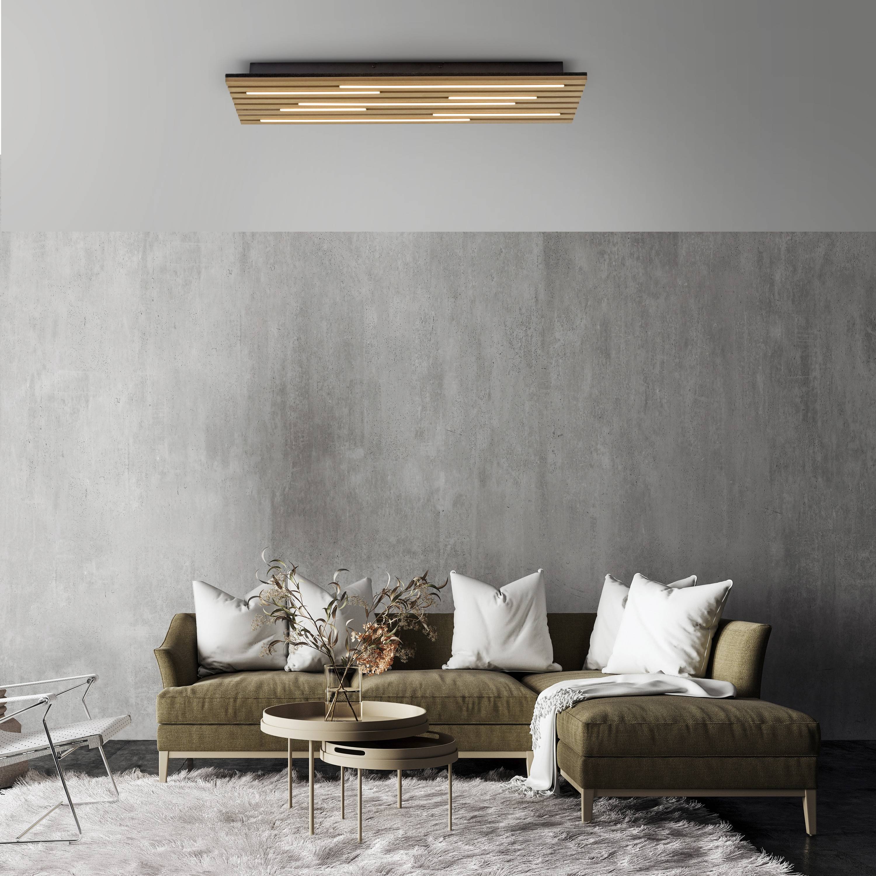 Ein modernes Wohnzimmer mit minimalistischem Design verfügt über ein graues Sofa mit weißen Kissen, einen runden Couchtisch und eine Holzleuchte.