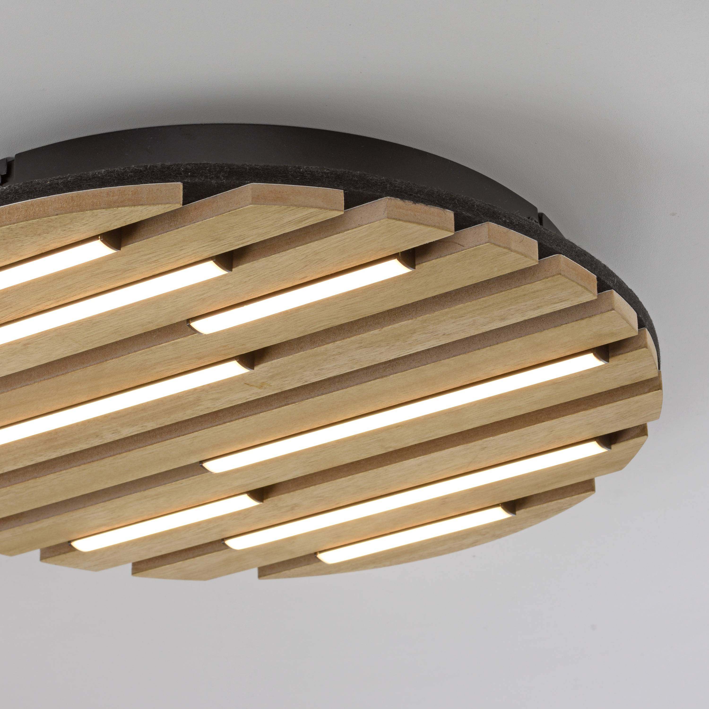 Eine runde Deckenleuchte mit Holzlamellen-Design strahlt ein warmes, weiches Licht aus und verleiht dem Raum eine moderne Ästhetik.