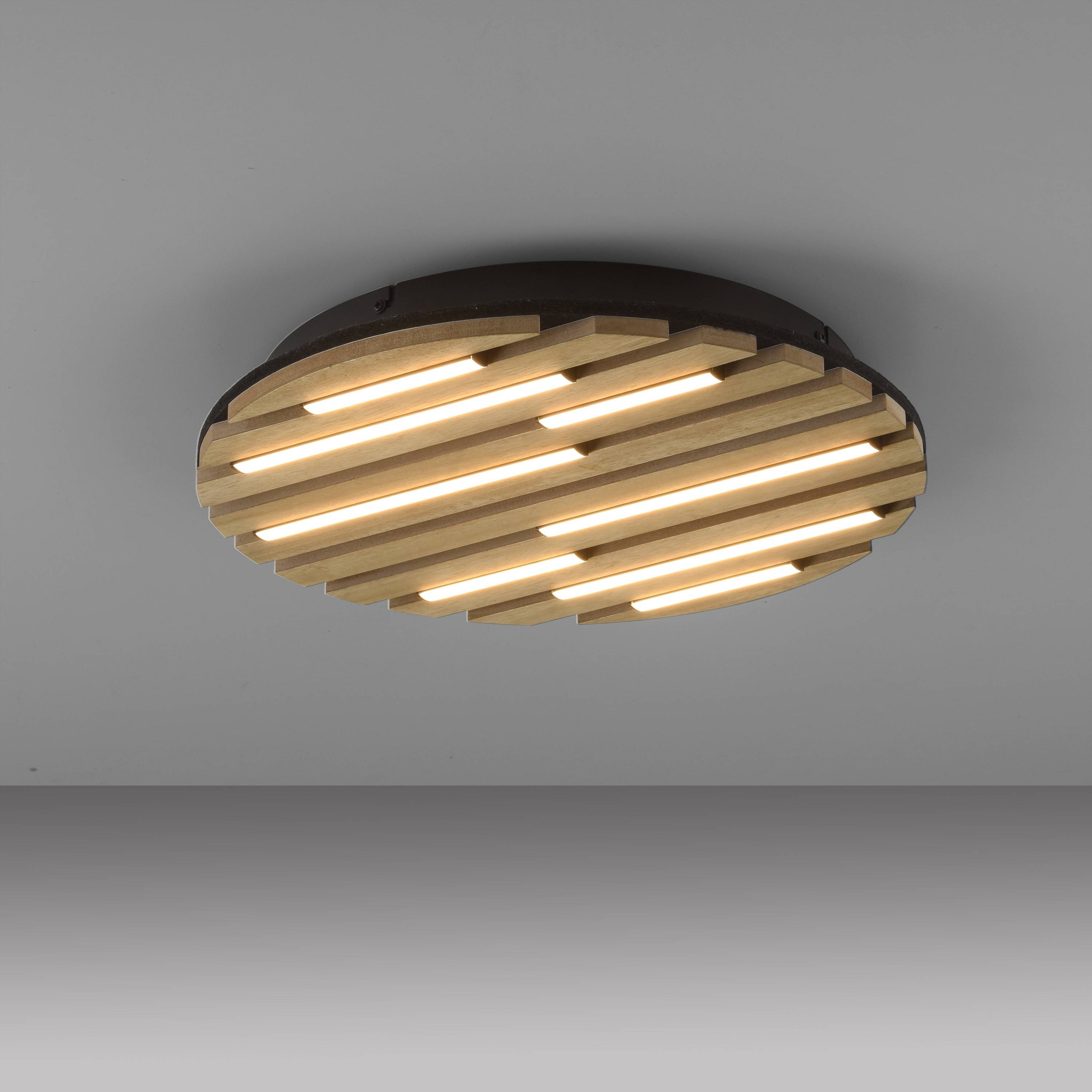 Eine moderne Deckenleuchte mit parallelen Holzlamellen und integrierten LED-Streifen, an einer grauen Decke montiert.