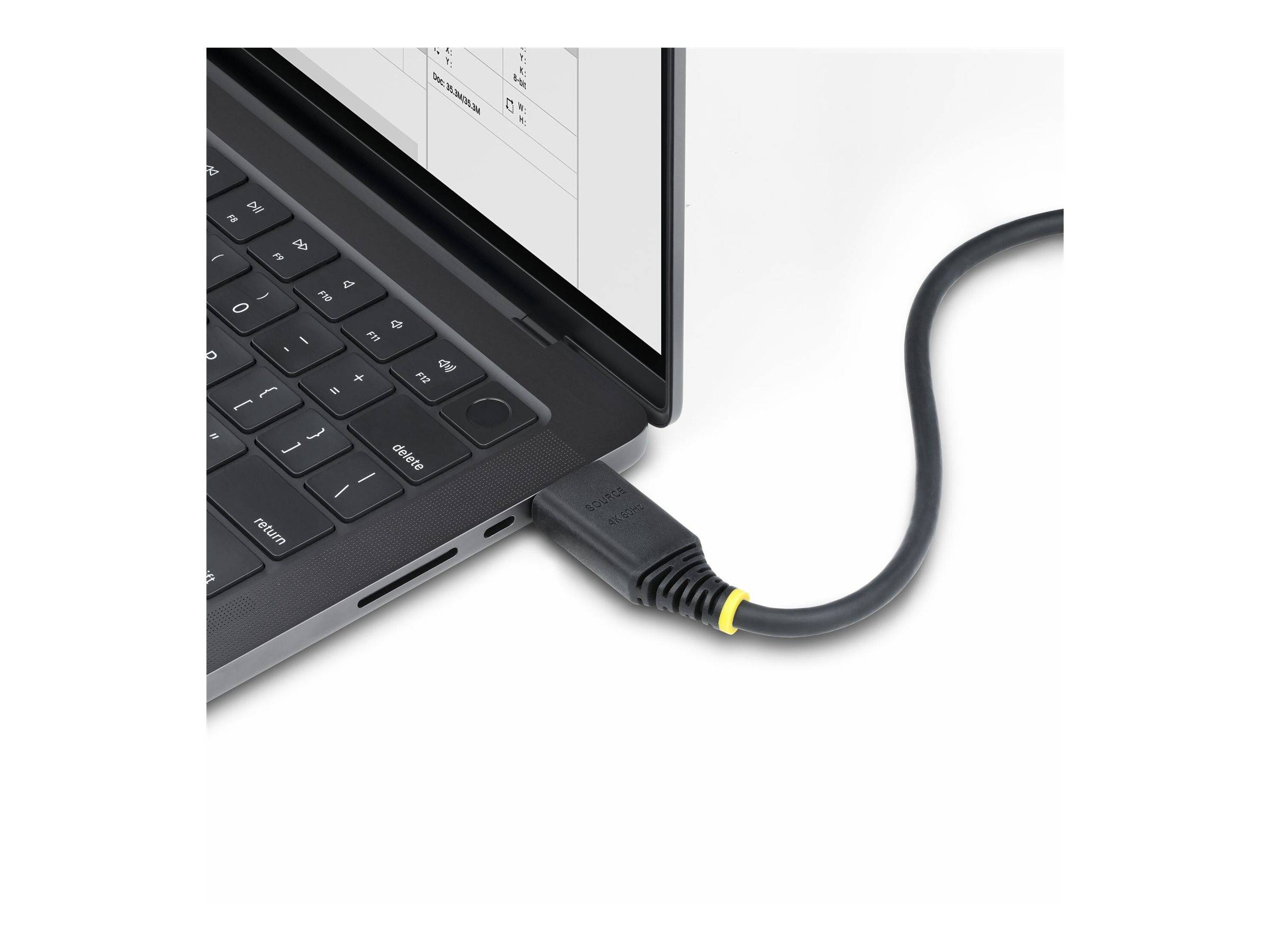 Ein Laptop mit einem Netzteil, das angeschlossen ist, mit einer Nahaufnahme der Tastatur und einem Teil des geöffneten Bildschirms, auf dem ein Dokument zu sehen ist.