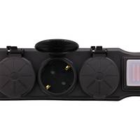 Eine schwarze Steckdosenleiste mit drei runden, abgedeckten Steckdosen, eine davon offen, wobei der Steckdoseneinsatz sichtbar ist.