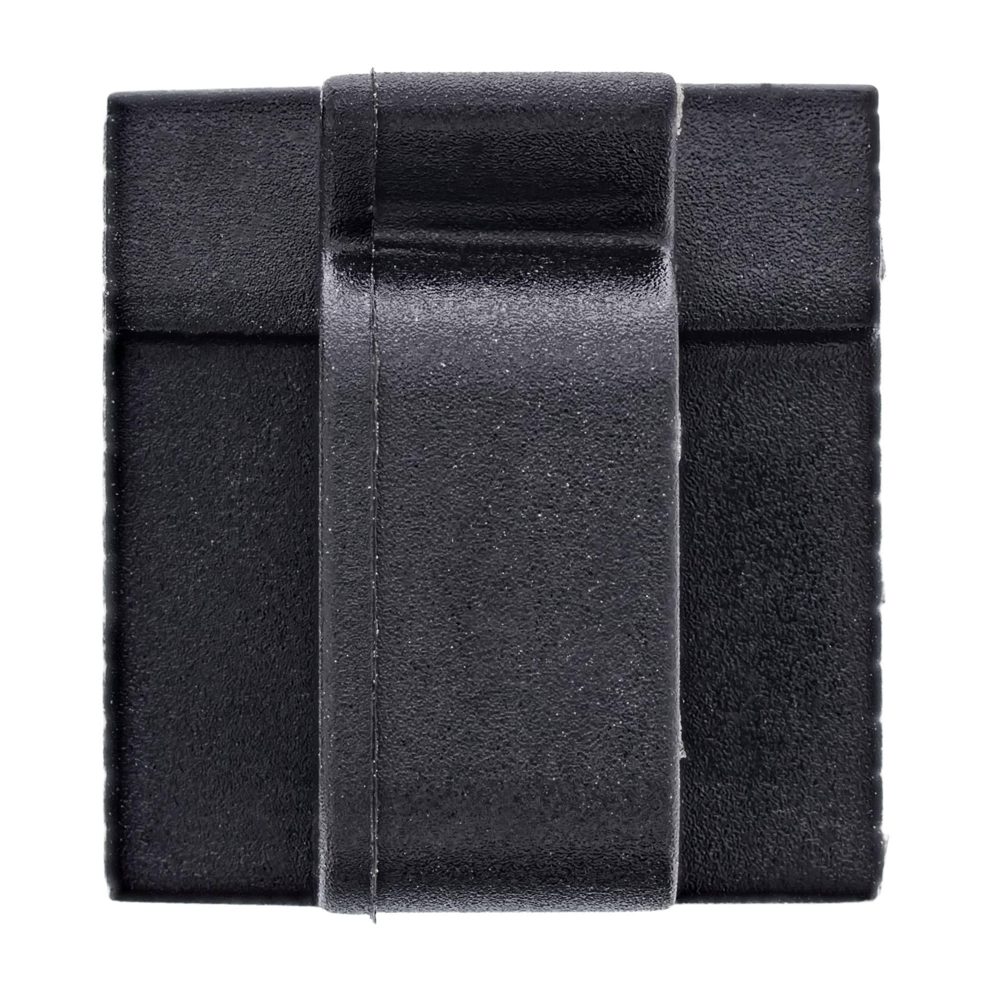 Eine Nahaufnahme eines schwarzen, quadratischen, strukturierten Objekts mit einem erhöhten, zentrierten, riemenartigen Merkmal, das sich vertikal über seine Oberfläche erstreckt.