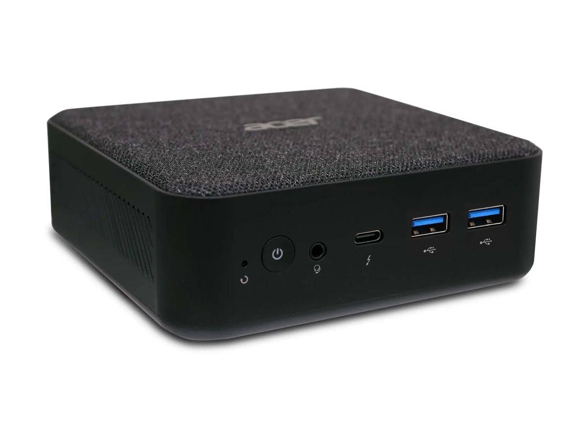 Eine kompakte schwarze Computerbox mit einer stoffartigen Oberfläche, die einen Einschalter, Kopfhörerbuchse, USB-C- und USB-A-Anschlüsse an der Frontplatte aufweist.
