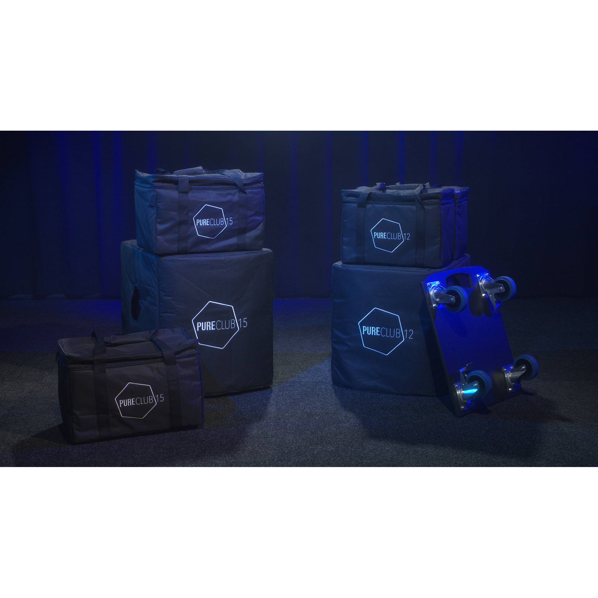 Blau beleuchtete Szene mit fünf dunklen Taschen unterschiedlicher Größen und einem Rollbehälter, beschriftet mit 'PURE CLUB' und sechseckigen Logos.