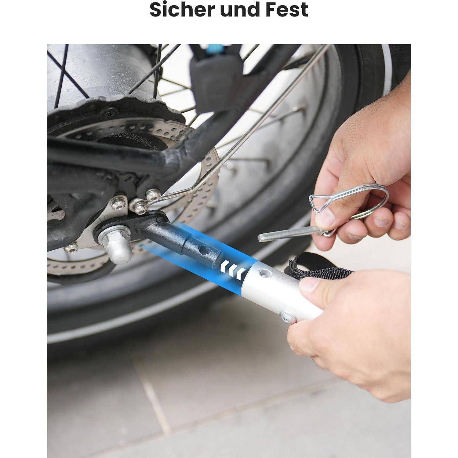 Eine Person verwendet ein blaues und silbernes Sperrgerät, um das Fahrradrad zu sichern. Das Schloss wird nahe der Hinterradachse des Fahrrads befestigt.