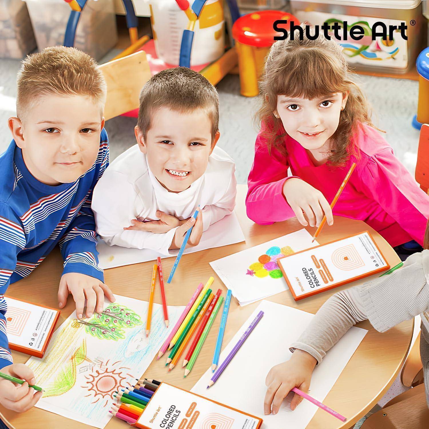 Vier Kinder lächeln um einen Tisch herum mit Kunstmaterialien und Malbüchern und beschäftigen sich gemeinsam kreativ in einem Klassenzimmer.