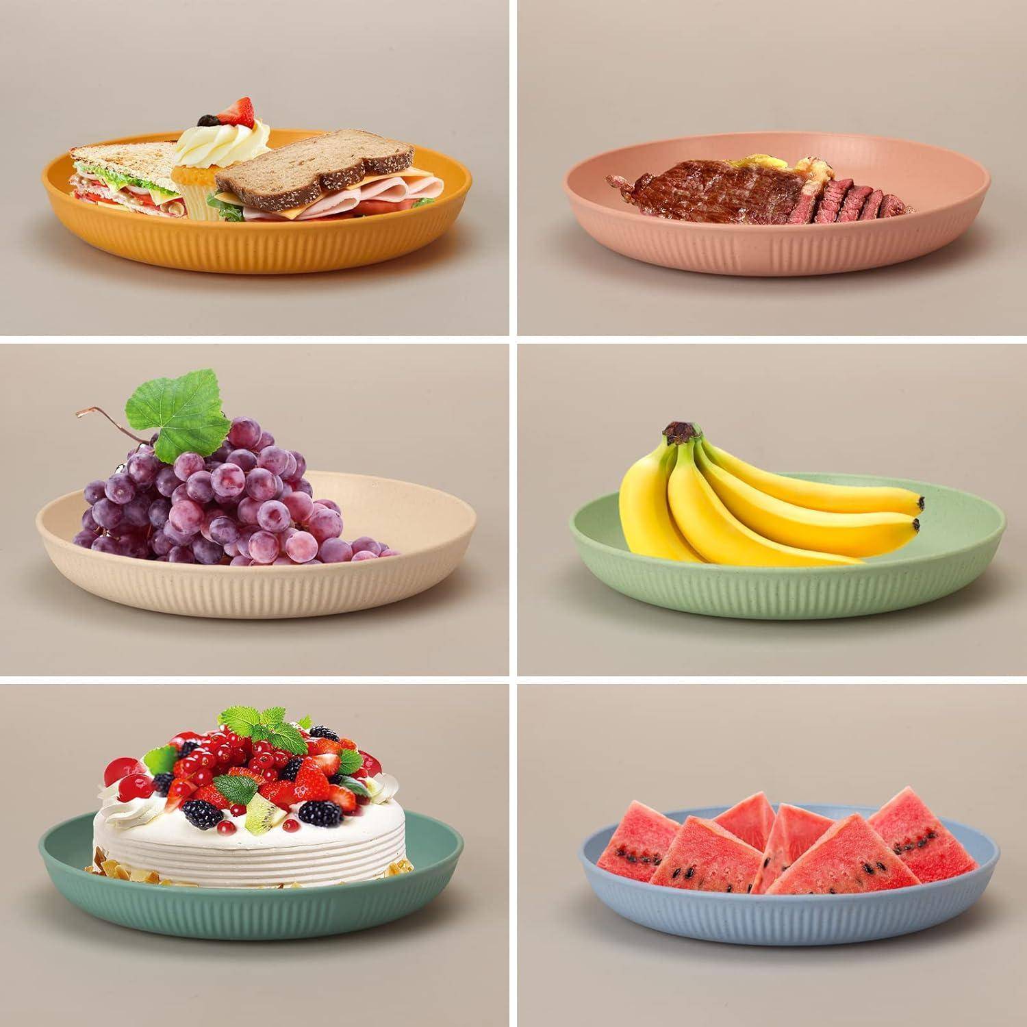 Sechs Teller mit Speisen: Sandwich und Salat, Steak, Trauben, Bananen, Obstkuchen, Wassermelonenscheiben. Jeder auf einem eigenen bunten Teller.
