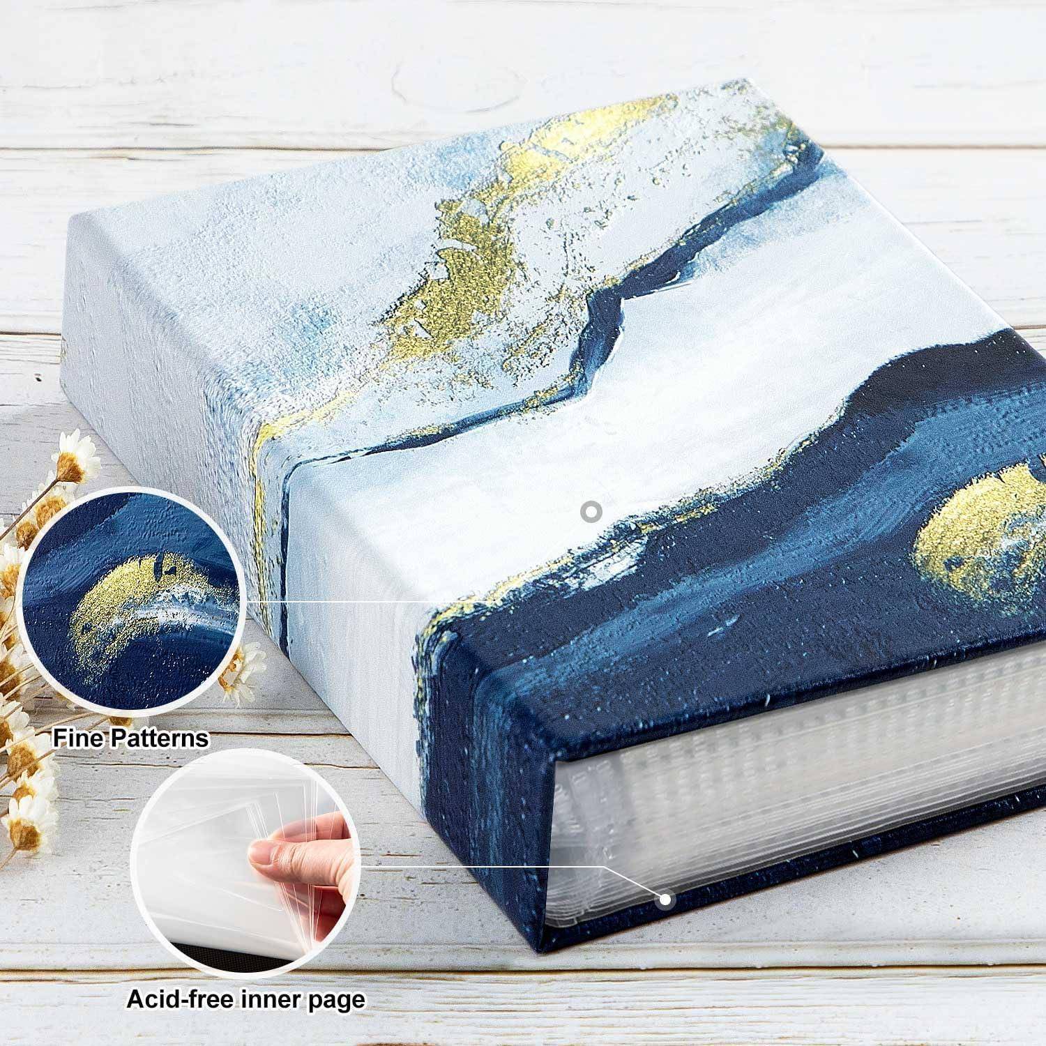Ein strukturiertes, blau und gold gemustertes Fotoalbum mit der Aufschrift 'Feine Muster' und 'Säurefreie Innenseiten' in einer Ecke.