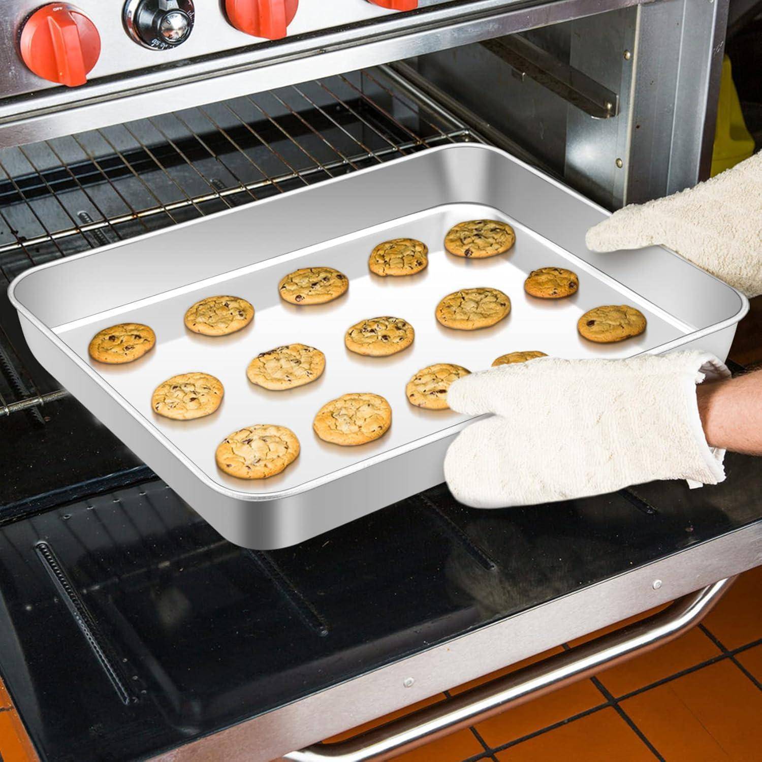 Eine Hand mit Handschuh nimmt ein Backblech mit frisch gebackenen Chocolate-Chip-Keksen aus einem silbernen Ofen, was einen warmen, selbstgemachten Leckerbissen andeutet.