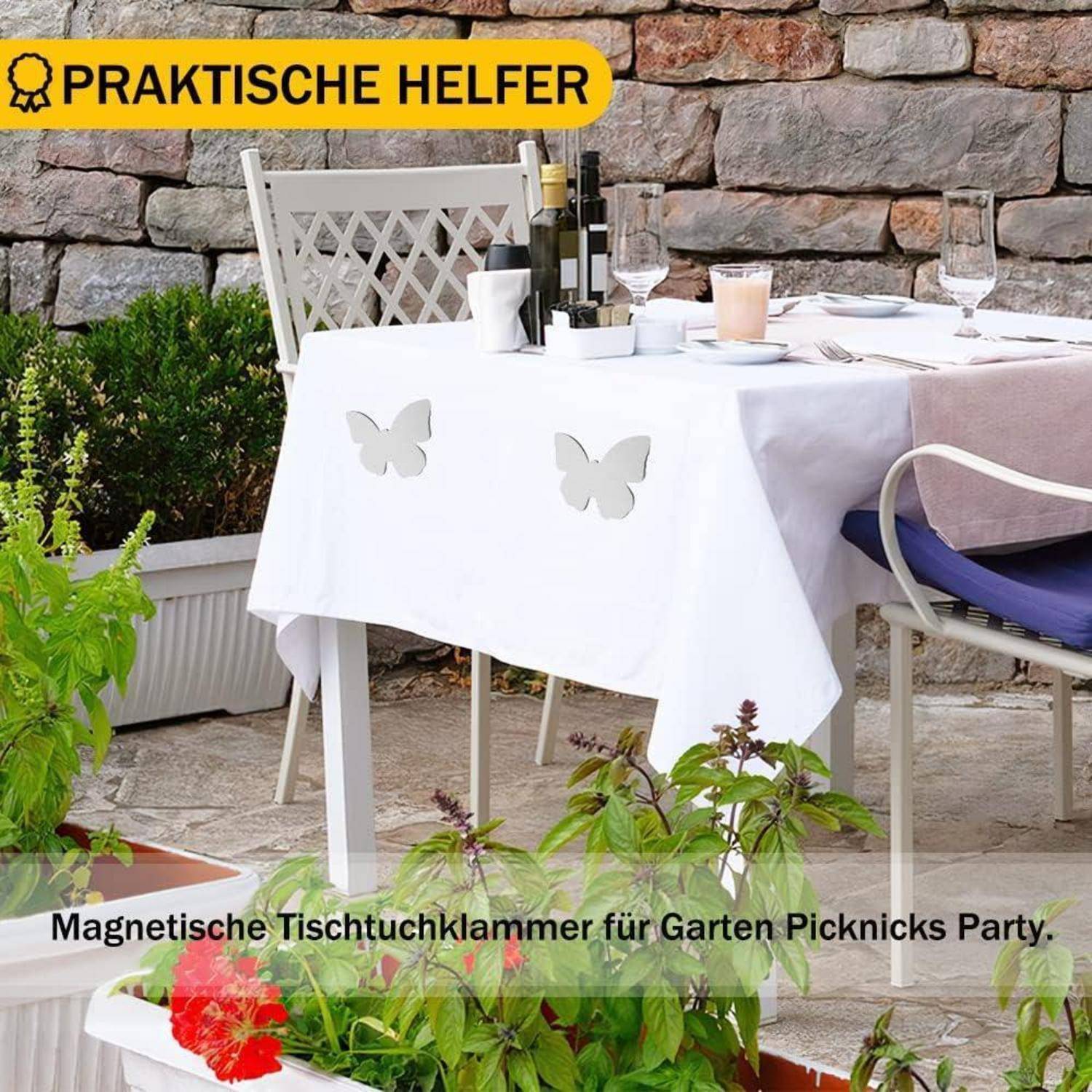 Outdoor-Tisch gedeckt mit Wein und Gläsern; dekorative magnetische Tischdeckenklammern in Schmetterlingsform halten die Tischdecke an ihrem Platz.