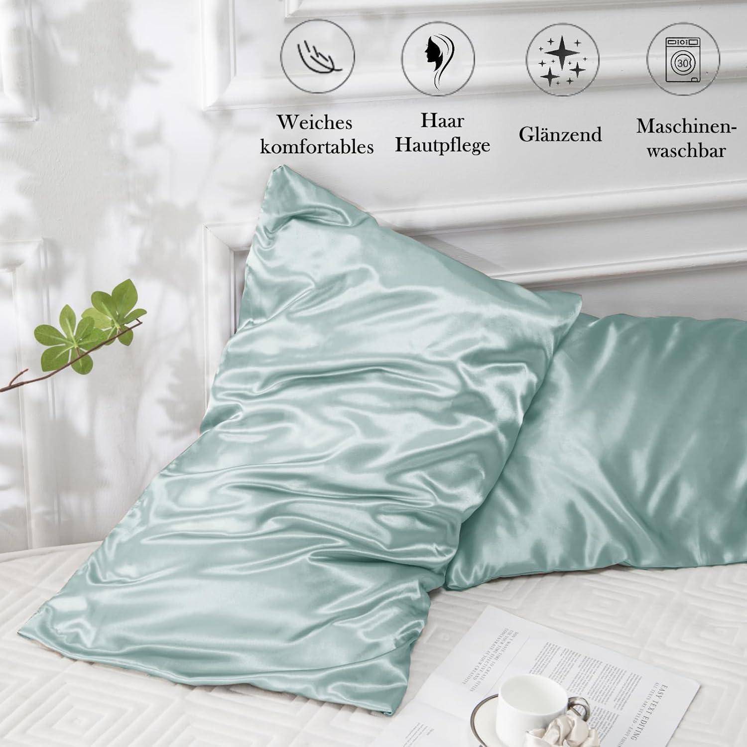 Hellgrüne Satin-Kissenbezüge auf einem Bett, die Weichheit, Hautpflege und Maschinenwäsche betonen. Im Hintergrund befindet sich eine Pflanze mit einem dezenten Schatten.