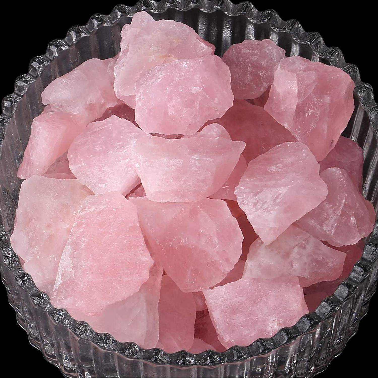 Eine Glasschale gefüllt mit rauen rosa Rosenquarz-Steinen, die ihre natürliche Textur und weiche rosa Nuance zur Geltung bringen.