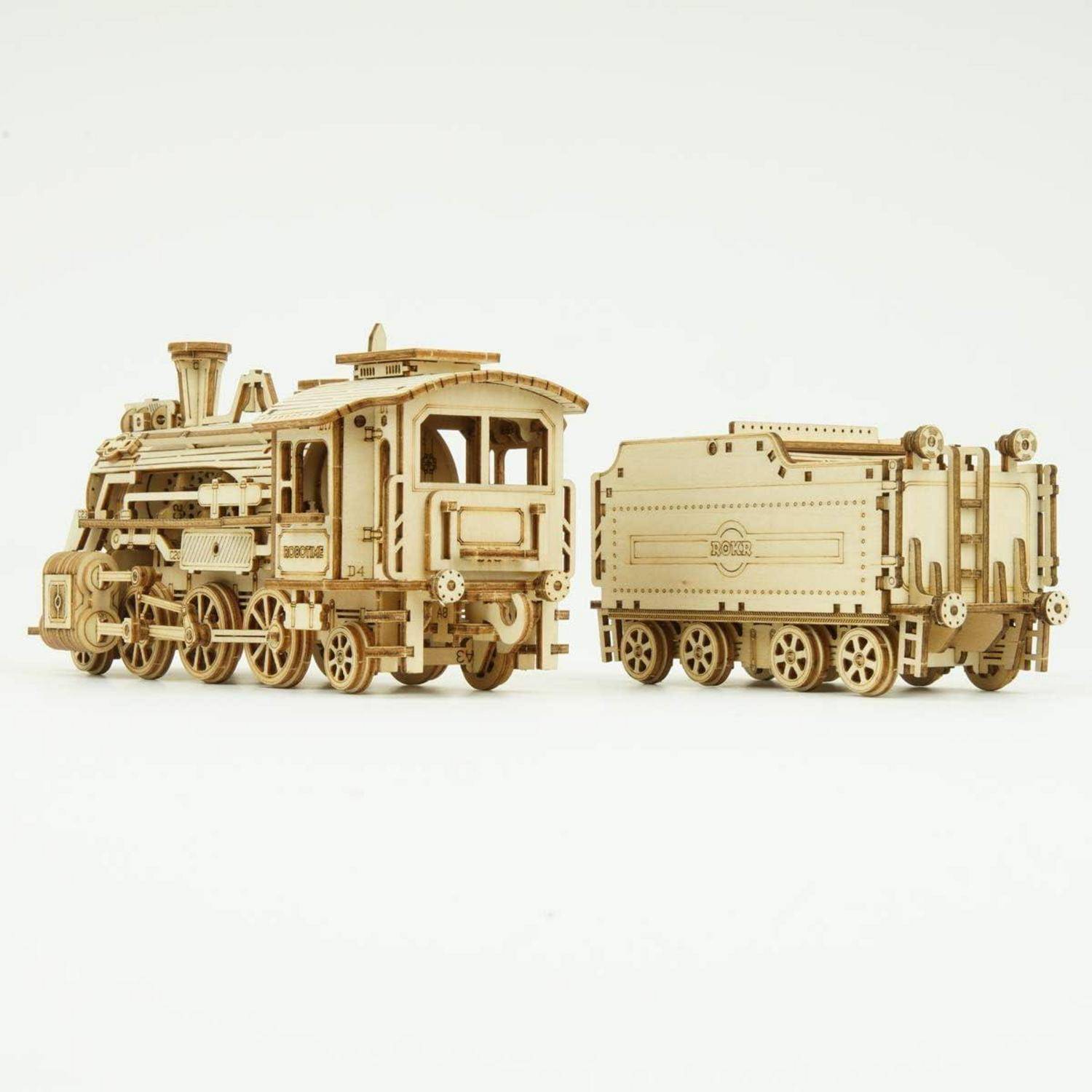 Ein Holzmodell eines Zuges und eines Autos mit detaillierten Einzelheiten und Zahnrädern, das eine zusammengebaute historische Lokomotive vor einem schlichten Hintergrund präsentiert.