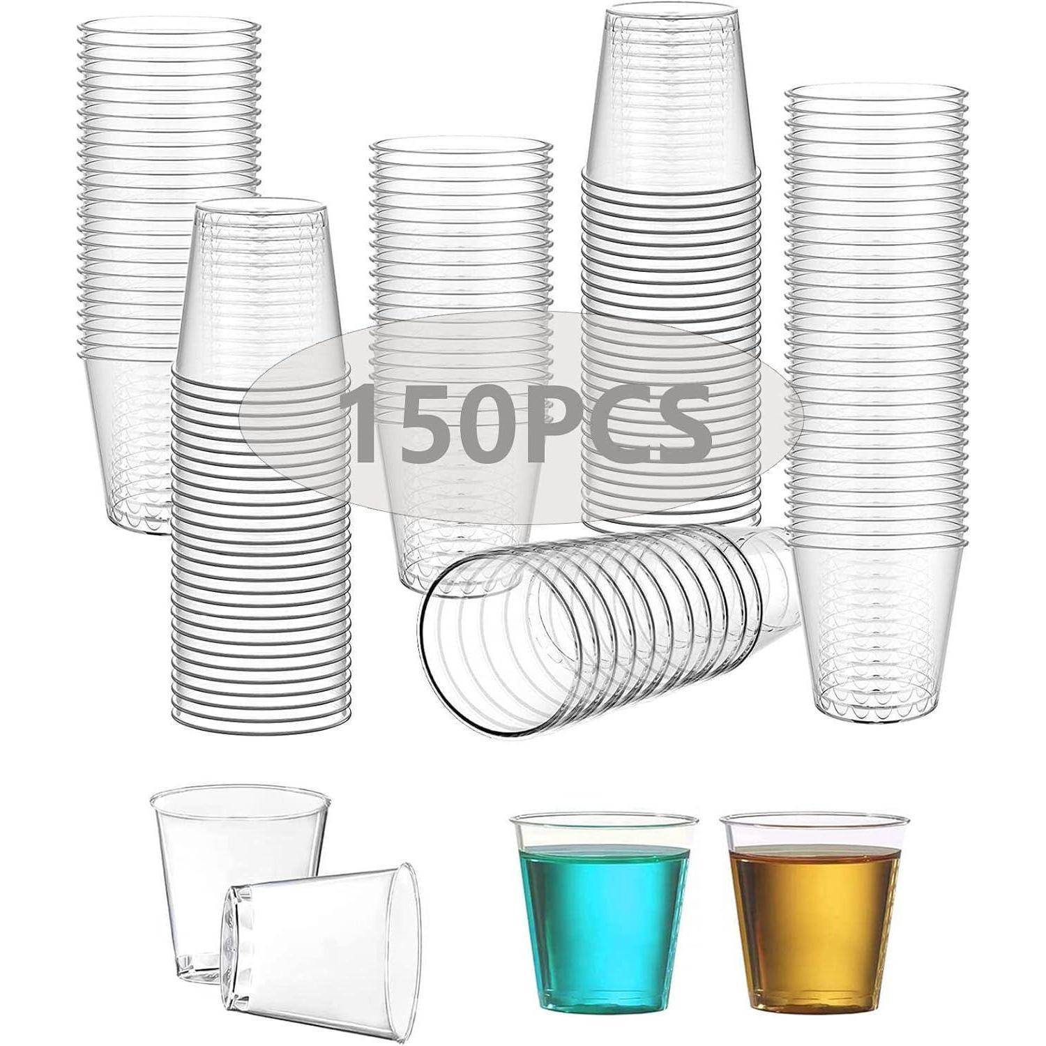 Eine Sammlung von 150 durchsichtigen Plastikbechern ist aufgestapelt, wobei zwei mit blauer und orangefarbener Flüssigkeit gefüllt sind, die ihre Transparenz zeigen.