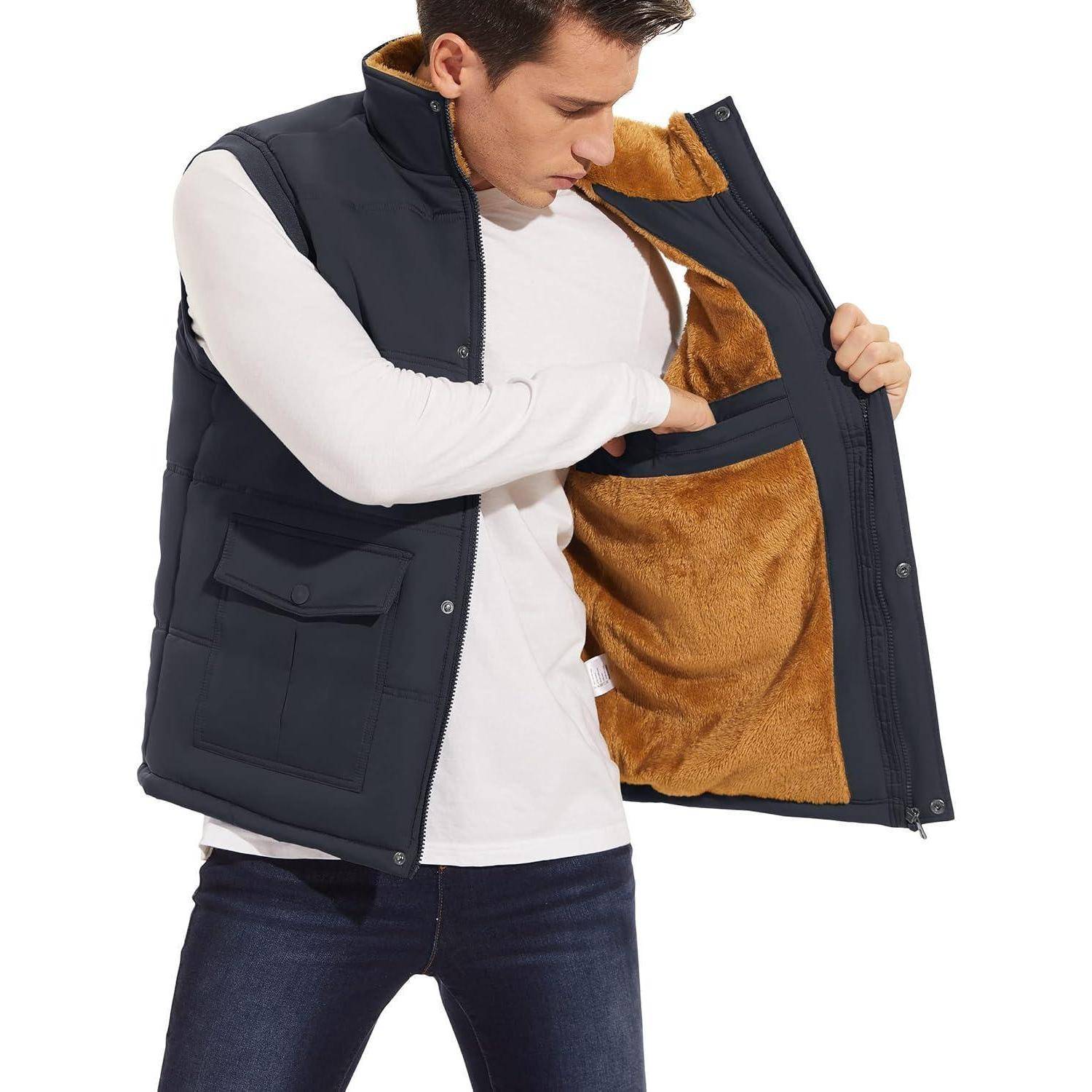 Ein Mann in einer marineblau-braunen Weste, deren Innenseite er inspiziert, trägt ein weißes Langarmhemd und dunkle Jeans vor einem einfarbigen Hintergrund.