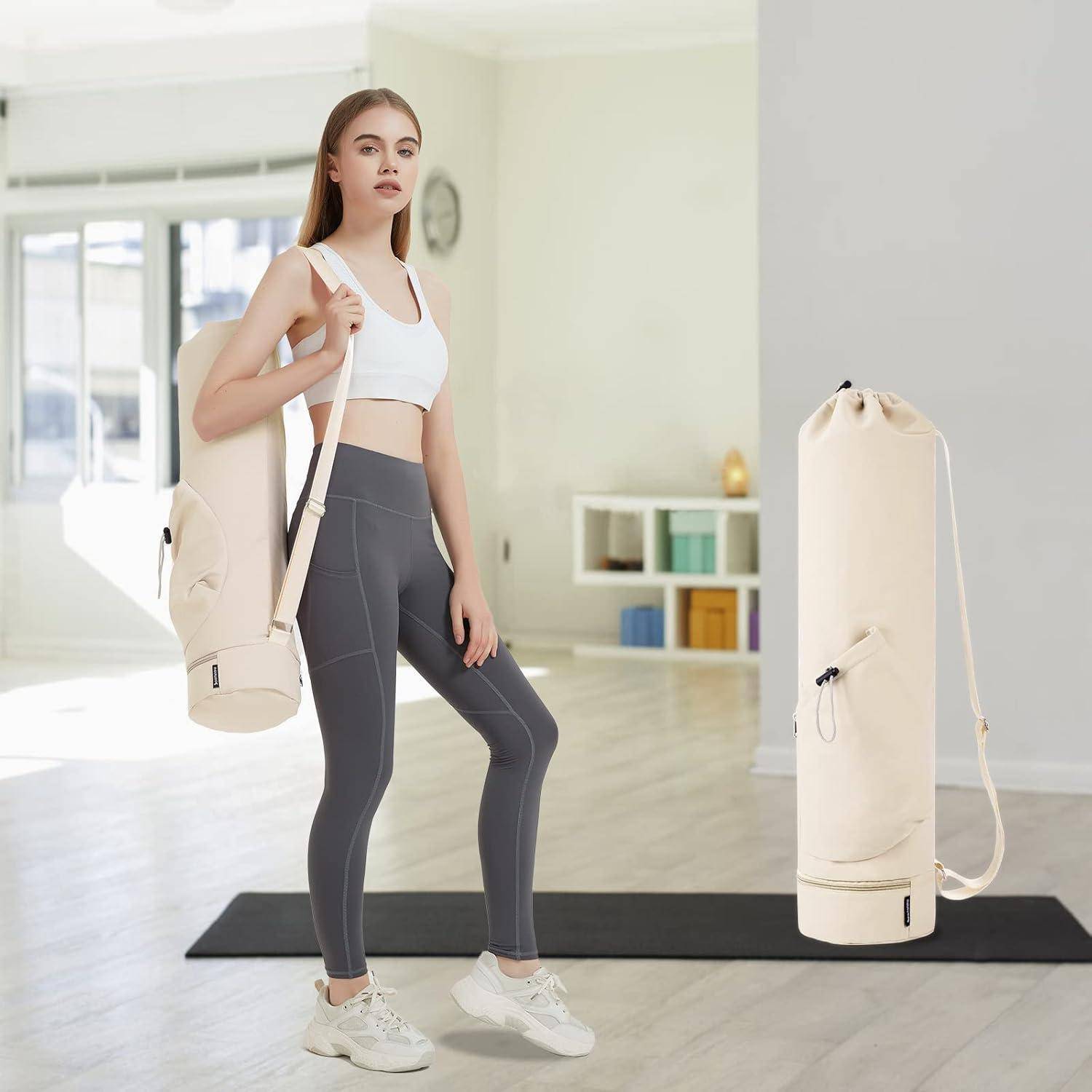Eine Frau in Sportkleidung steht in einem sonnendurchfluteten Raum, trägt eine Yogamatten-Tasche über ihrer Schulter und hat eine Übungsmatte in der Nähe auf dem Boden liegen.