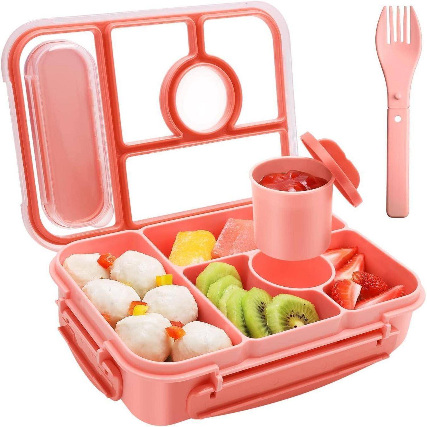 Eine rosa Brotdose ist geöffnet und zeigt Knödel, Ananas, Kiwischeiben und Erdbeeren. Ein kleiner Behälter mit Deckel enthält Sauce. Ein passender rosa Löffel-Gabeln-Kombination (Spork) ist in der Nähe platziert.