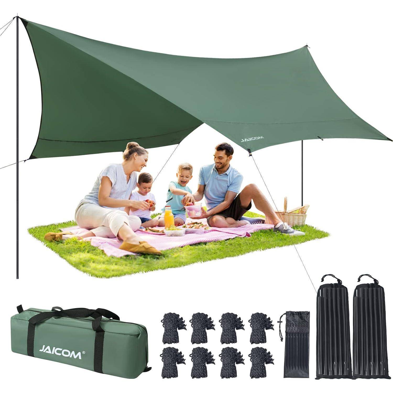 Eine vierköpfige Familie genießt ein Picknick auf einer Decke unter einem grünen Sonnenschutz-Pavillon. In der Nähe befinden sich eine Tragetasche, Heringe, Seile und Stangen.