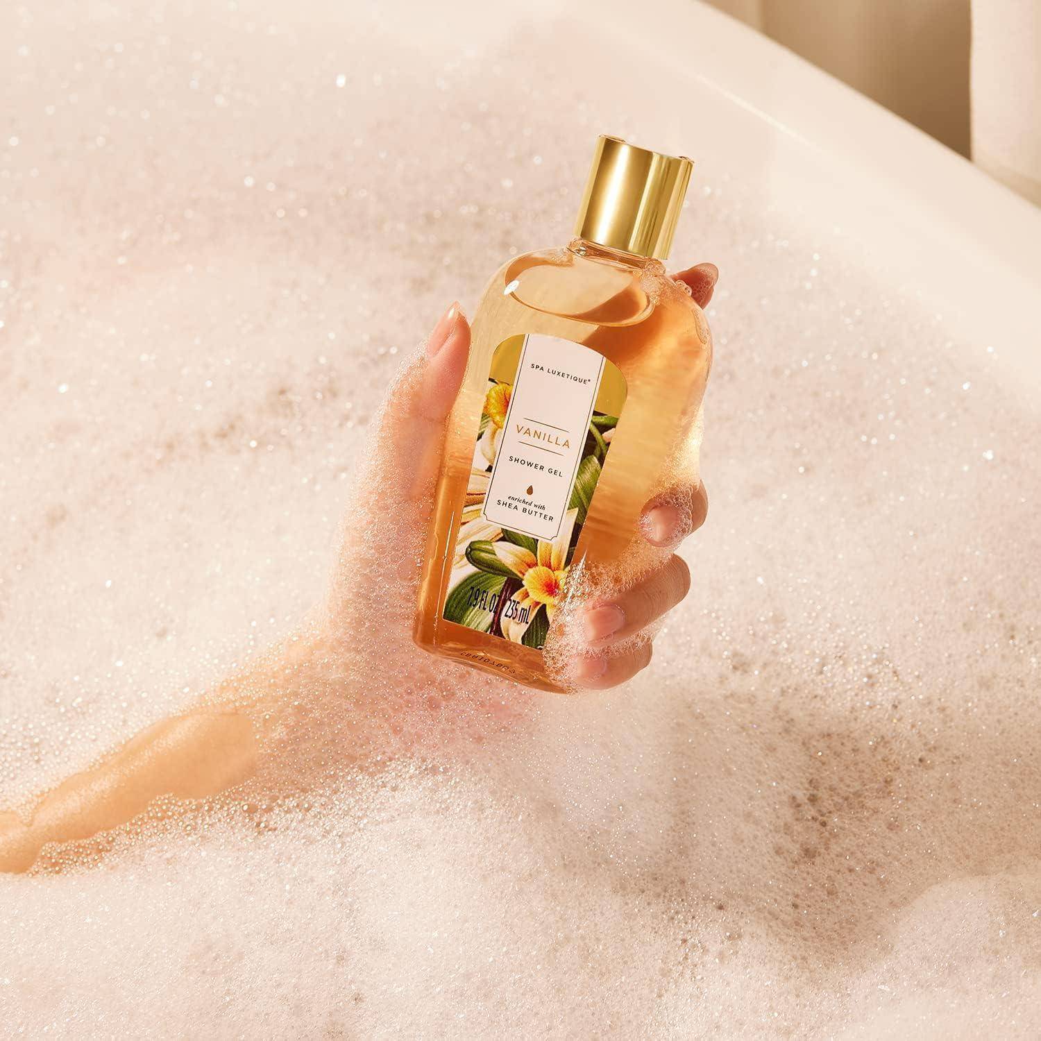 Eine Hand, die eine Flasche Duschgel mit Vanilleduft über schaumiges Badewasser in einer Badewanne hält.