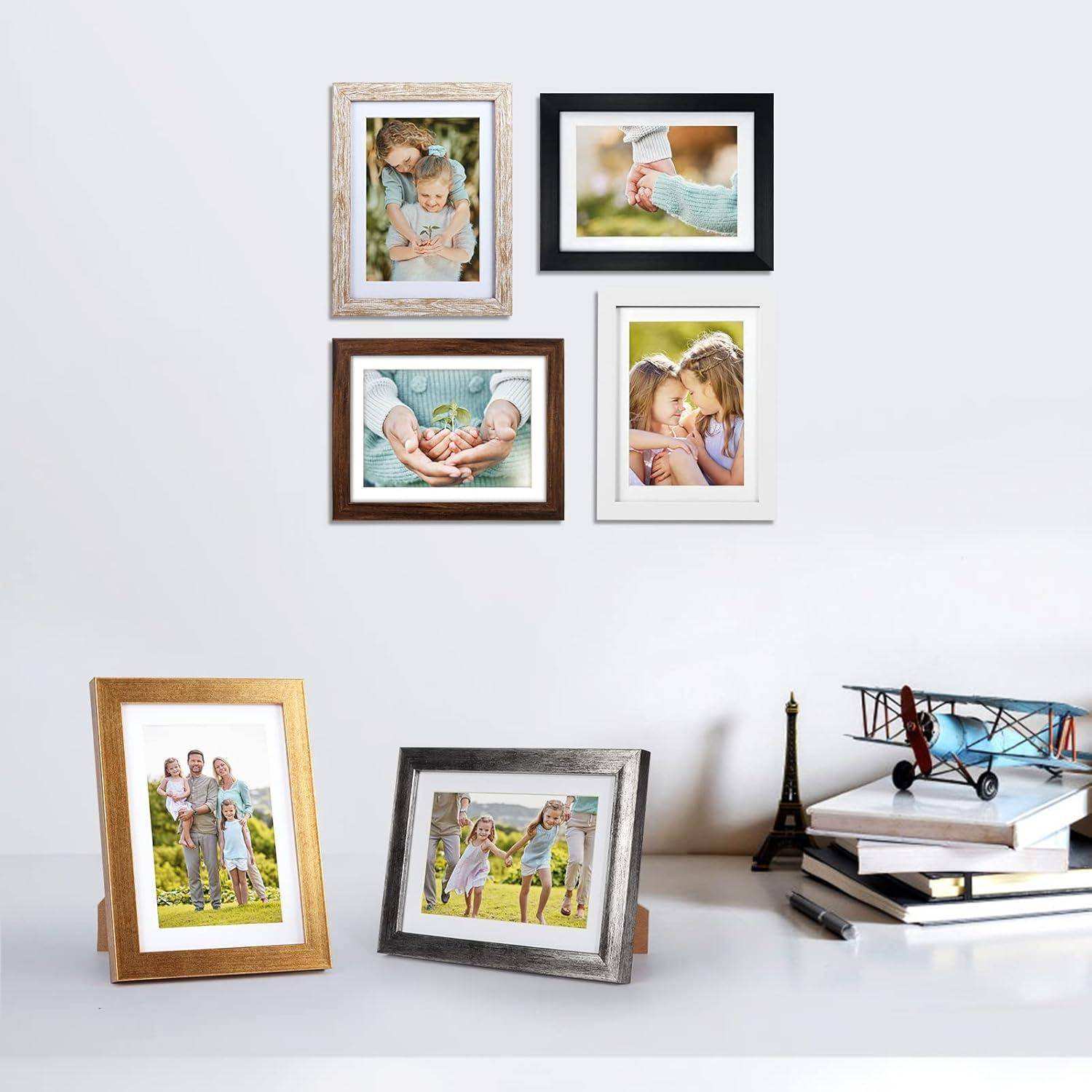 Eine Wand mit sechs Bilderrahmen und ein Tisch mit zwei Bilderrahmen, die Familienmomente und ein Spielzeugflugzeug präsentieren; eine gemütliche Wohnumgebung.