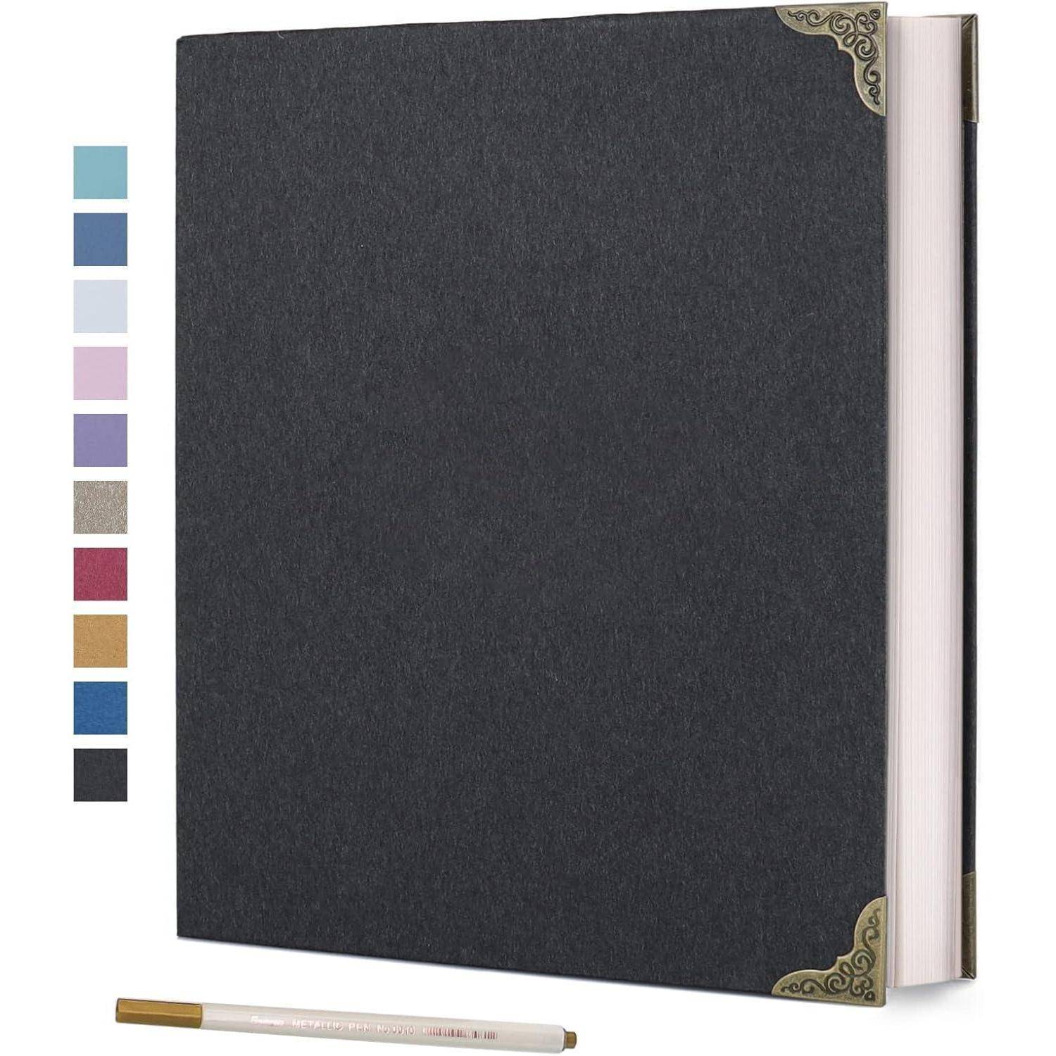 Ein schwarzes Notizbuch mit dekorativen Eckverzierungen auf dem Einband, begleitet von einem Stift. Verschiedene Farbmuster sind daneben zu sehen.