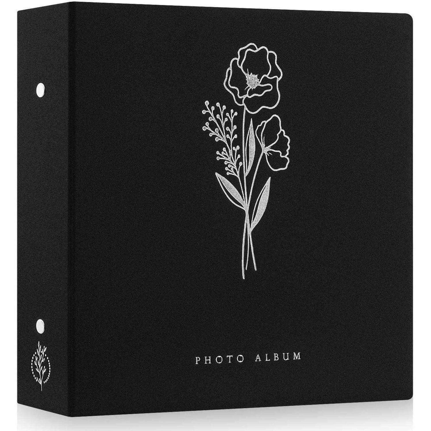 Eine schwarze Fotoalbumhülle mit einer weißen Blumenillustration und den Worten 
