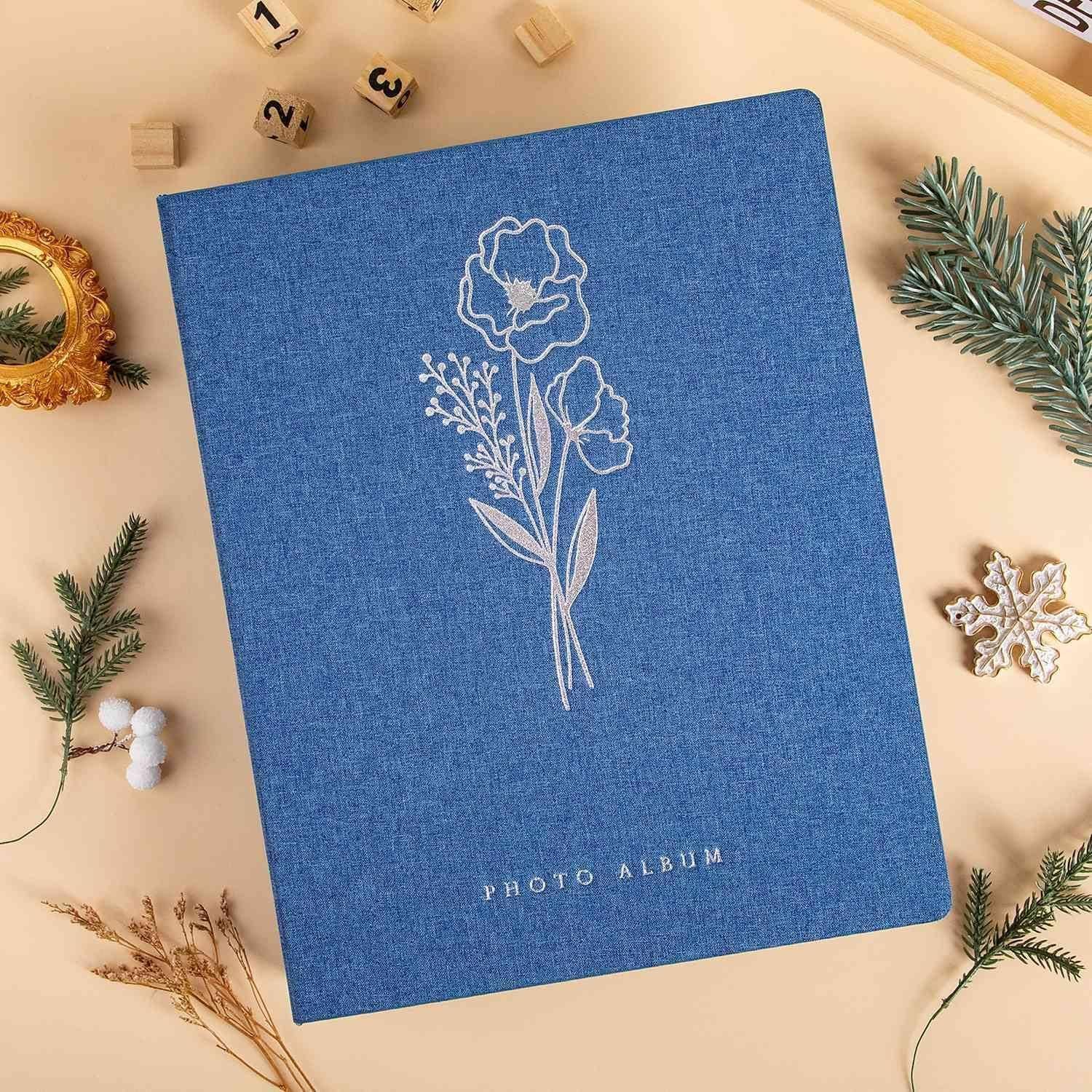 Ein blau-weißes Fotoalbum mit floralem Muster und der Aufschrift 