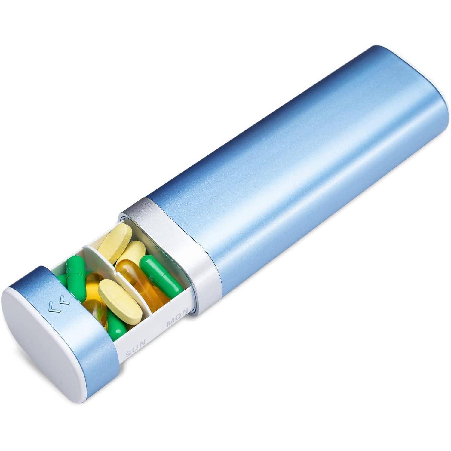 Eine blaue rechteckige Pillendose mit einem Schiebdeckel zeigt gelbe und grüne Kapseln im Inneren.