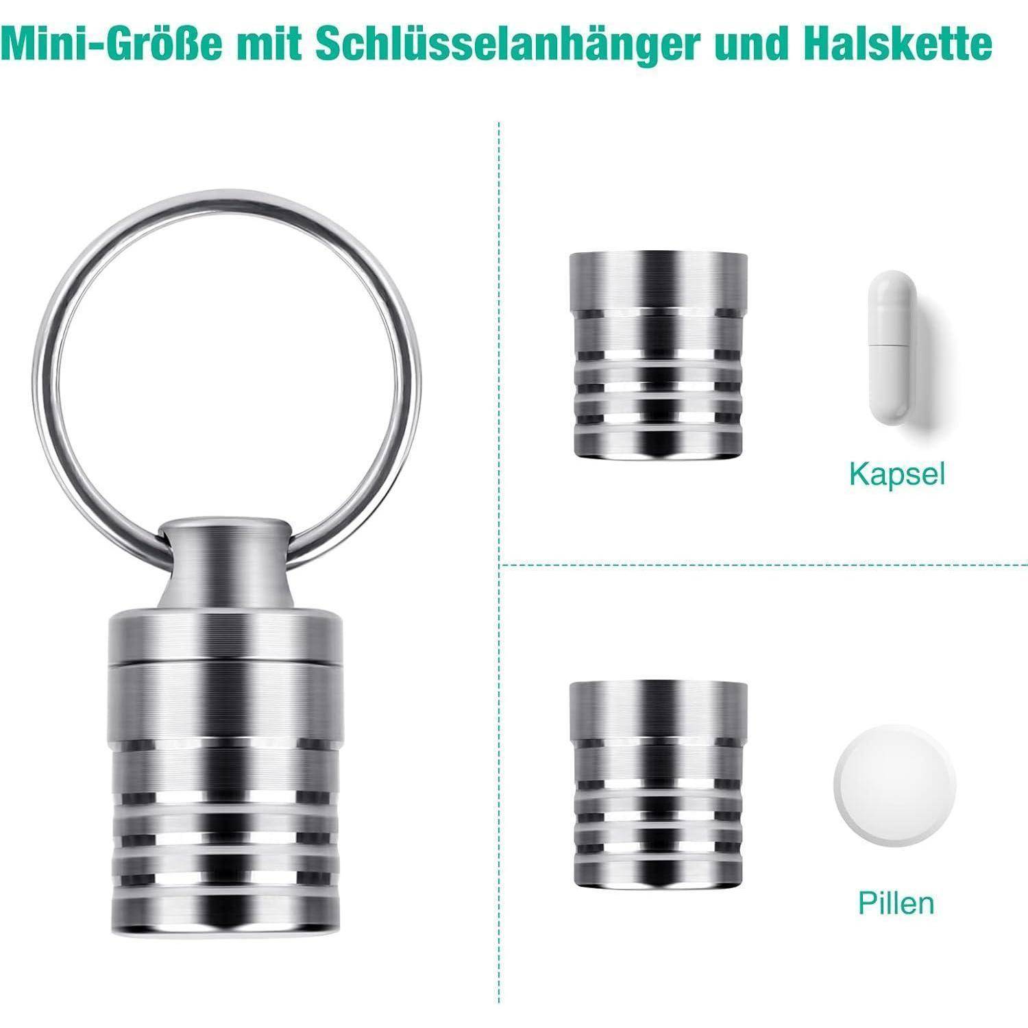Ein kleiner metallischer Pillendose mit Schlüsselanhänger- und Halskettenmöglichkeiten, die neben einer Kapsel und einer Pille zur Größenvergleich gezeigt wird.