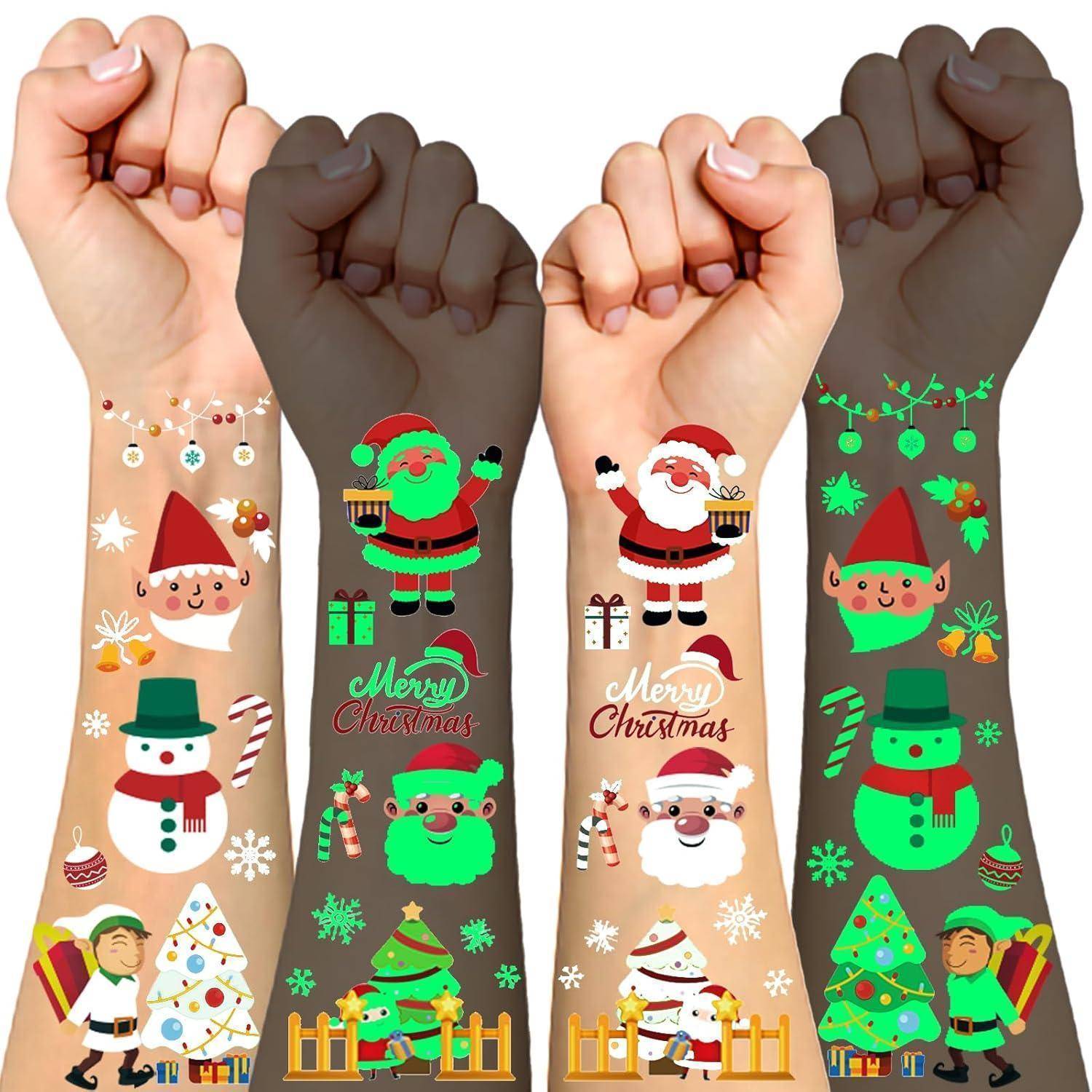 Arme mit festlichen Weihnachts-Motivtattoos, die Weihnachtsmänner, Schneemänner, Weihnachtsbäume und Zuckerstangen zeigen.