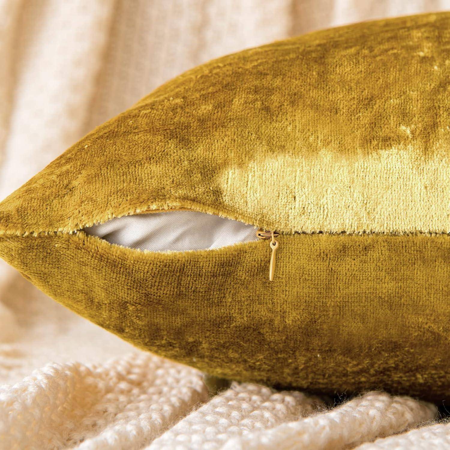 Ein weiches, goldenes Samtkissen mit sichtbarem Reißverschluss liegt auf einem strukturierten Stoff-Hintergrund und vermittelt Gefühle von Komfort und Luxus.