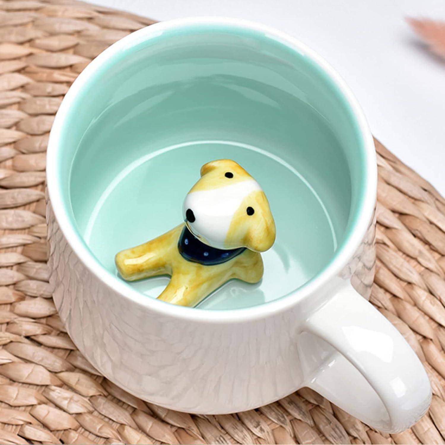 Eine weiße Tasse mit hellblauem Innenraum zeigt eine kleine keramische gelbe Hundefigur am Boden, die auf einer gewebten Matte platziert ist.