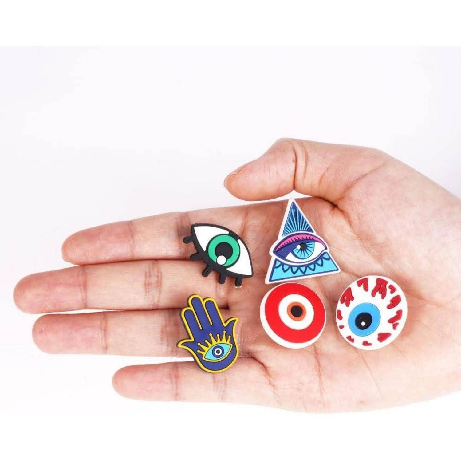 Eine Hand hält fünf bunte Symbole: ein Auge in einem Dreieck, ein Augapfel, ein Auge mit Wimpern, eine gelbe Hand und eine Augenlinse.