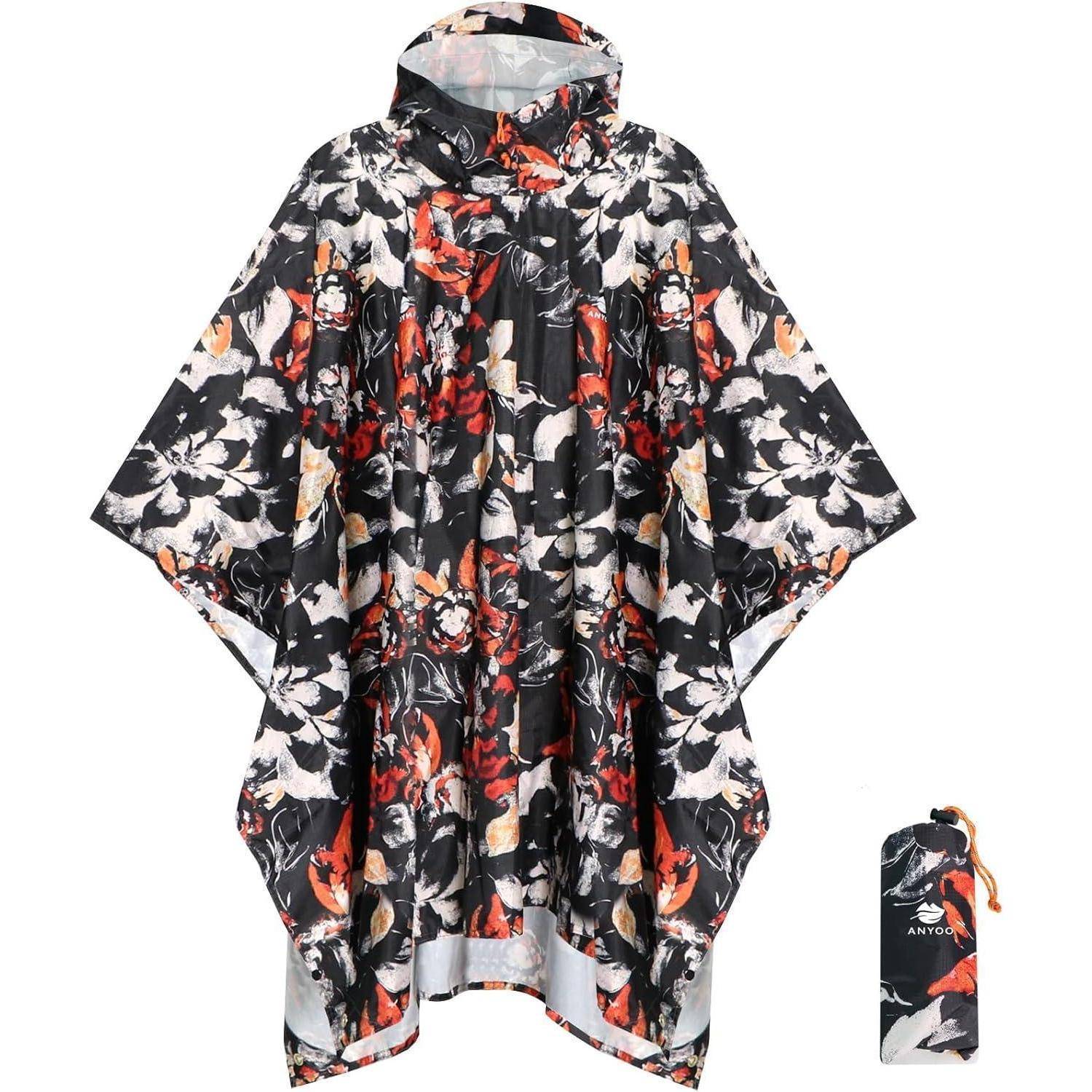 Ein florale gemusterter Poncho in Schwarz-, Weiß- und Rotfarben, mit einer passenden Tasche daneben ausgestellt.