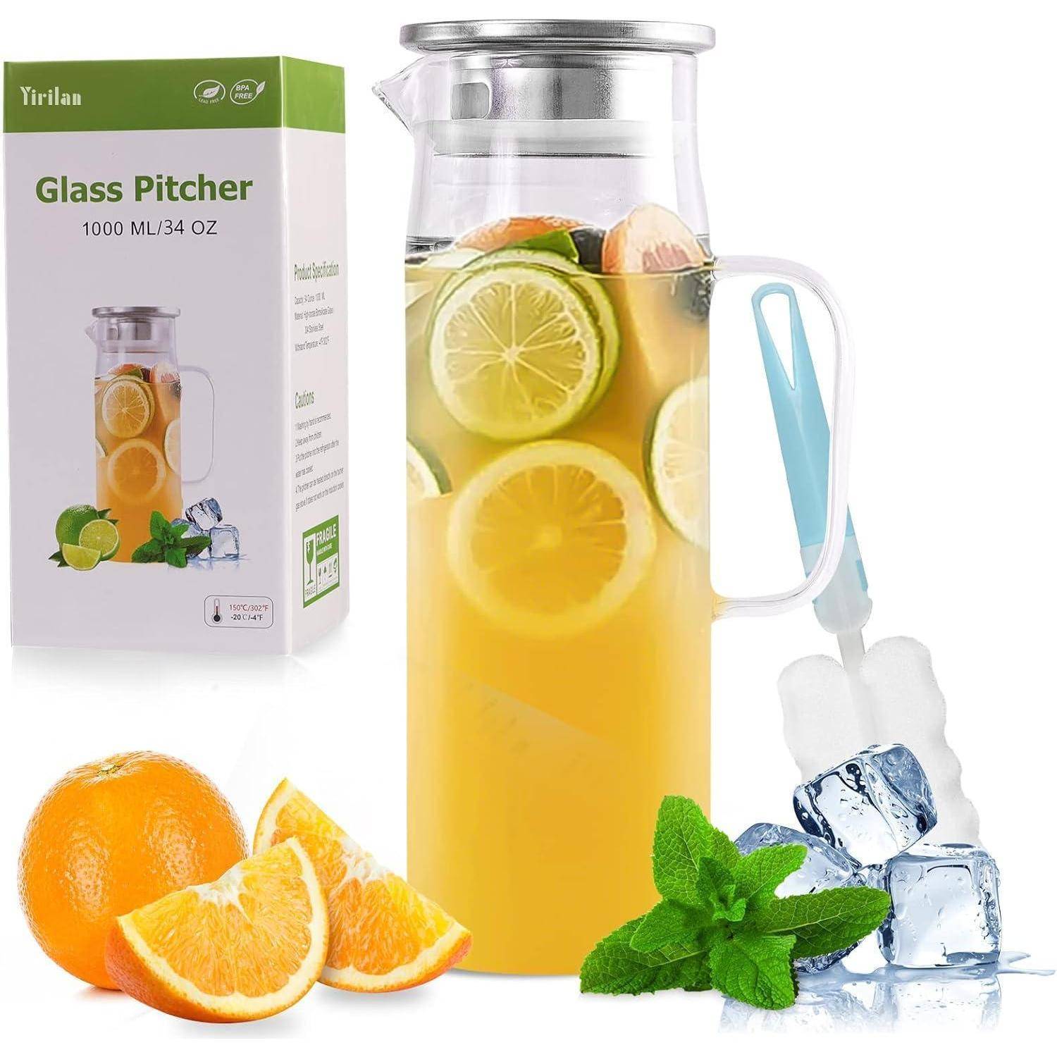 Ein Glaskrug gefüllt mit Zitronenscheiben und Flüssigkeit, neben einer Schachtel mit der Aufschrift 'Glaskrug 1000 ML/34 OZ'. Umgeben von Orangen, Minze und Eis.