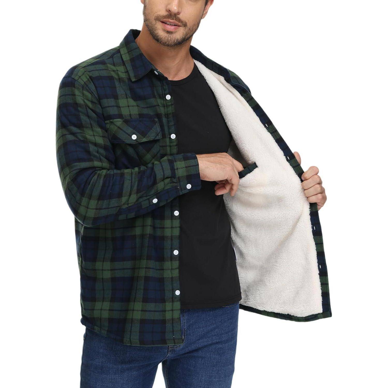 Eine Person zeigt die weiche Innenseite eines grün-marineblau karierten Flanellhemds, während sie ein schwarzes T-Shirt und Jeans trägt.