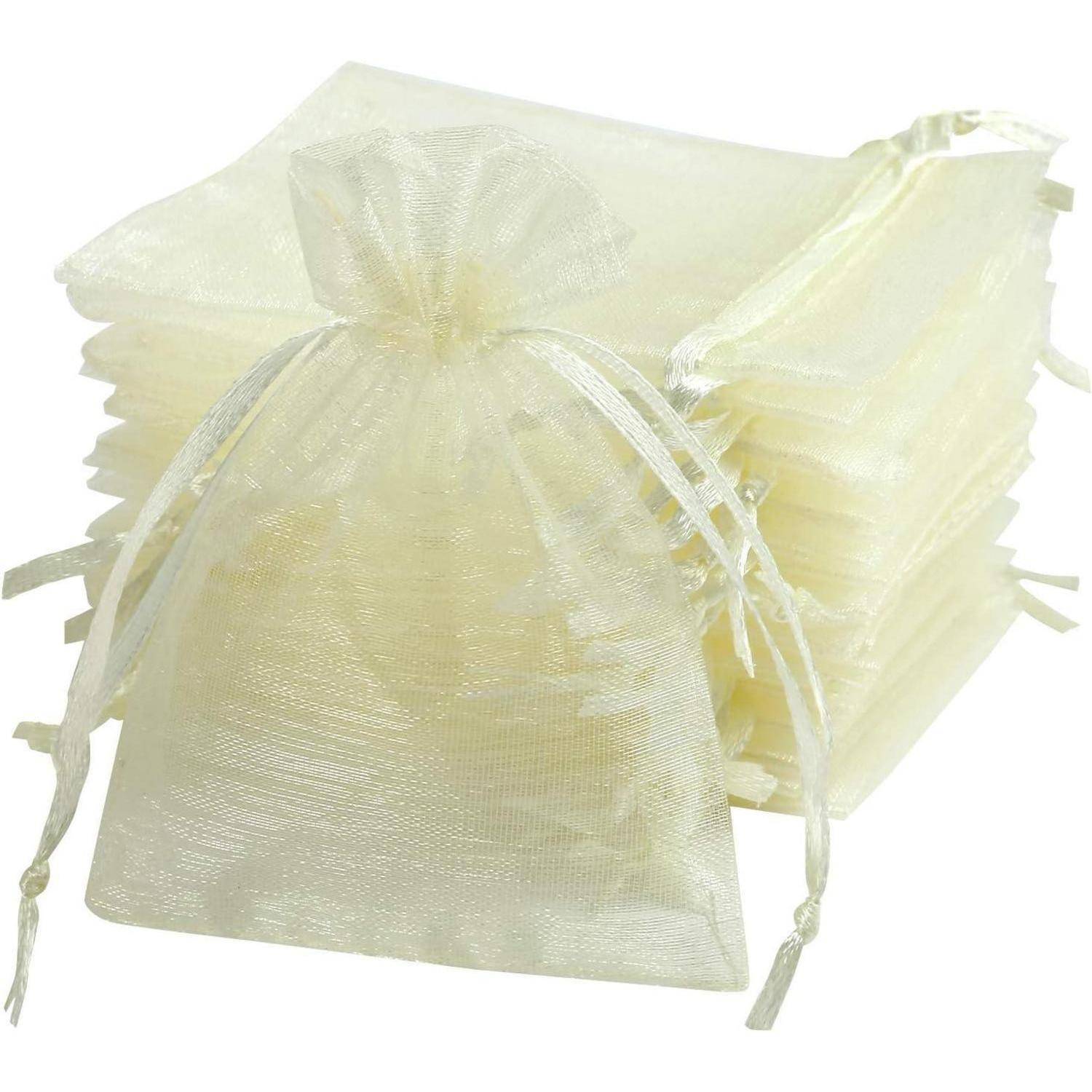 Ein Stapel elfenbeinfarbener Organza-Kordelzugbeutel neben einem aufrecht stehenden Beutel, was die Verwendung für Geschenke oder kleine Aufbewahrungsgegenstände andeutet.