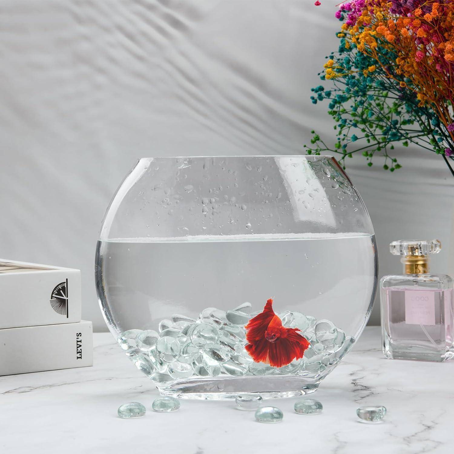 Ein Betta-Fisch mit einem fließenden roten Schwanz schwimmt in einer durchsichtigen Glasschüssel, die mit Wasser und Glaskieseln gefüllt ist, neben einem bunten Blumenstrauß.