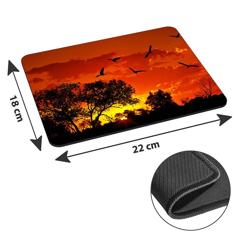 Ein Mousepad mit einer Sonnenuntergangslandschaft, in der Bäume und Vögel als Silhouetten zu sehen sind, mit den Abmessungen 22 cm x 18 cm und einer rutschfesten Rückseite.