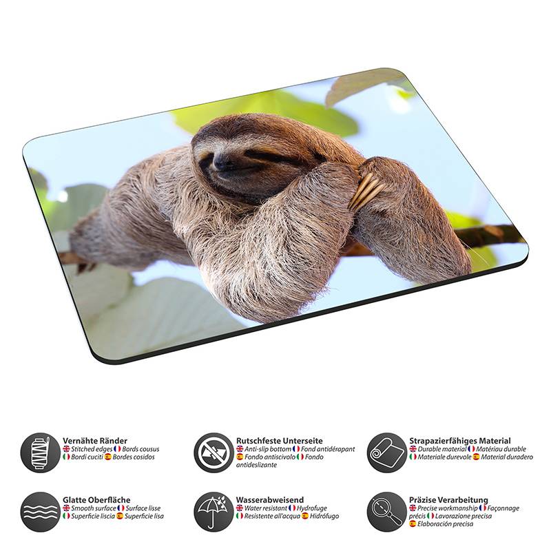 Ein Faultier, das von einem Baumast in einer Regenwaldumgebung hängt, ist auf einem Mousepad gedruckt. Icons unterhalb zeigen Merkmale wie rutschfeste Basis und Wasserbeständigkeit.