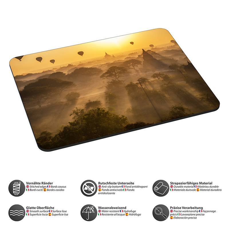 Mousepad mit einem Bild einer Sonnenaufgangslandschaft mit Heißluftballons über Bäumen. Icons unten heben Produktmerkmale hervor: Haltbarkeit, Griffigkeit und Wasserbeständigkeit.