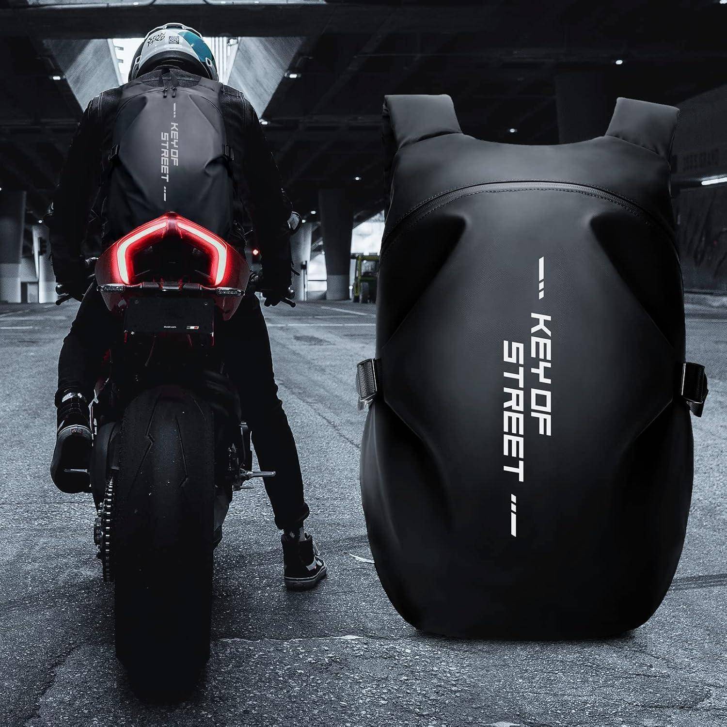 Ein Motorradfahrer mit einem großen schwarzen Rucksack, auf dem "Key of Street"" steht, fährt unter einer Brücke hindurch und betont dabei den stylischen Rucksack.