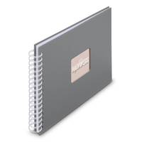 Ein graues Spiralgebundenes Notizbuch mit einem kleinen rechteckigen Etikett auf der Vorderseite.