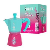 Aqua- und rosa Mokka-Kanne mit der Aufschrift 'Bialetti Limited Edition' neben passender Schachtel mit demselben Topfbild und 'Squid Game' Text.