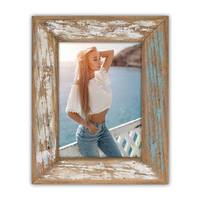 Eine Person steht an einem Geländer mit Ozean und Klippen im Hintergrund, trägt ein weißes Oberteil und Jeans, gerahmt von rustikalem Holz.