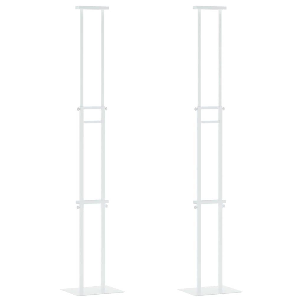 Zwei hohe, schlanke, weiße Metallstrukturen mit rechteckigen Basen und offenen Rahmen vor einem einfarbigen Hintergrund.