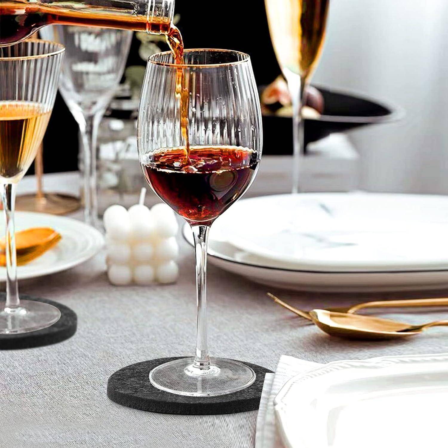 Rotwein, der in ein Glas auf einem Tisch eingegossen wird, der mit Tellern, Besteck und Kerzen gedeckt ist und eine formelle Tischdekoration andeutet.